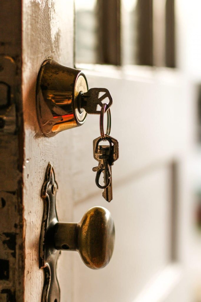 deadbolt lock installed on a door with its key inserted on it