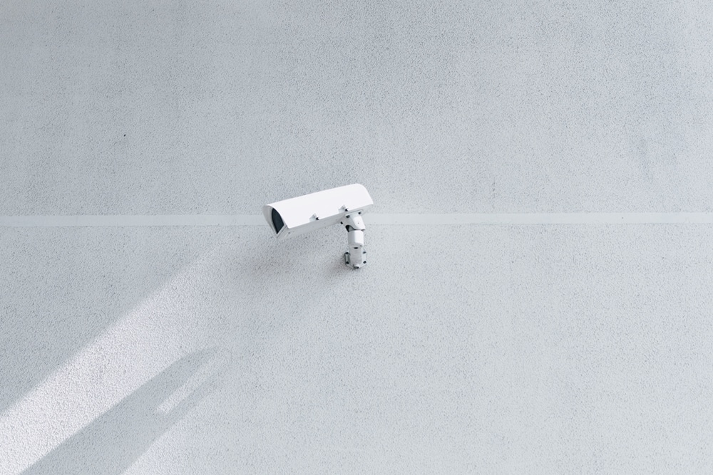 white security camera attached to the wall