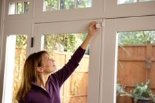Lady mounting wireless door sensor onto door
